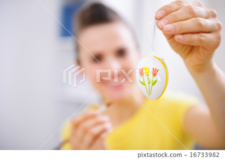 Closeup on Easter egg in hand of painting woman Closeup on Easter egg in hand of painting woman 16733982