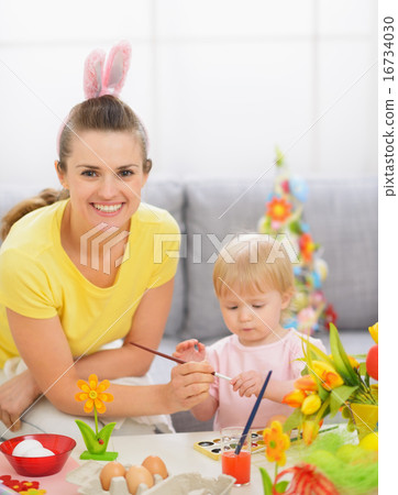 Happy mother and baby painting on Easter eggs Happy mother and baby painting on Easter eggs 16734030