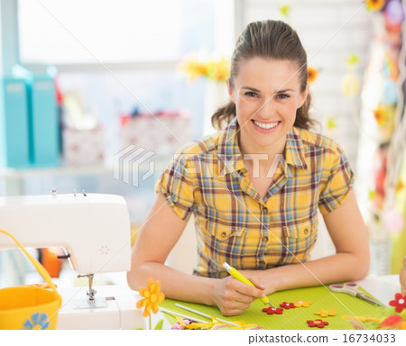 Smiling young woman making easter decoration Smiling young woman making easter decoration 16734033