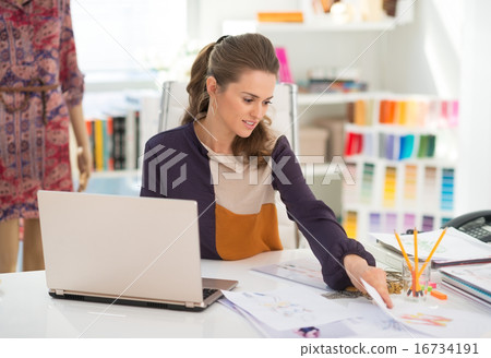 Fashion designer with laptop working in office Fashion designer with laptop working in office 16734191