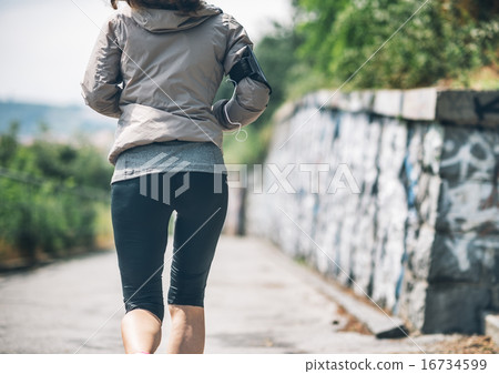 Closeup on fitness young woman jogging in the city park. rear vi Closeup on fitness young woman jogging in the city park. rear vi 16734599