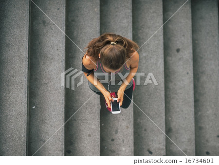 Portrait of fitness young woman cell phone with outdoors in the 16734601
