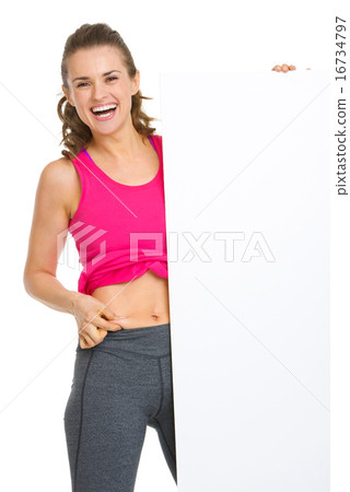 Happy fitness young woman checking body fat and showing blank bi Happy fitness young woman checking body fat and showing blank bi 16734797