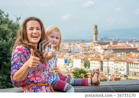 Happy mother and baby girl showing thumbs up against panoramic v Happy mother and baby girl showing thumbs up against panoramic v 16735170