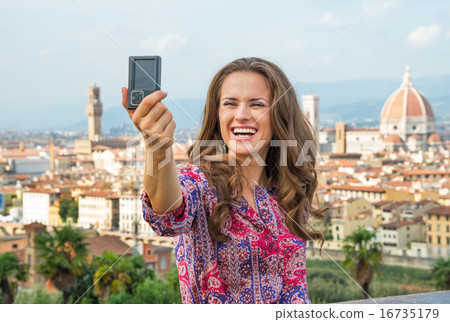 Happy young woman making selfie against panoramic view of floren 16735179
