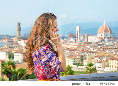 Young woman talking cell phone against panoramic view of florenc Young woman talking cell phone against panoramic view of florenc 16735190