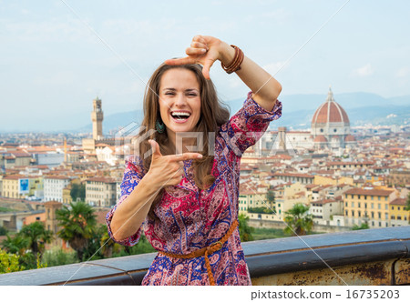 Happy young woman framing against panoramic view of florence, it Happy young woman framing against panoramic view of florence, it 16735203