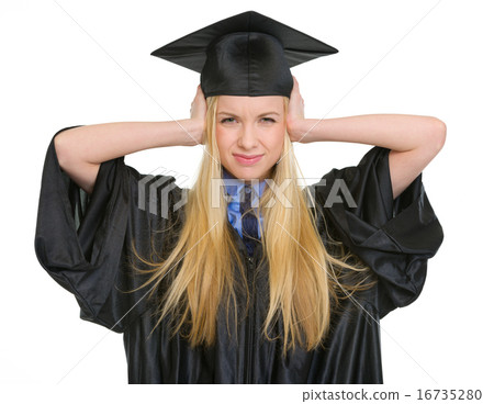 Frustrated young woman in graduation gown closing ears 16735280