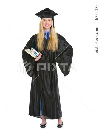 Full length portrait of young woman in graduation gown with book Full length portrait of young woman in graduation gown with book 16735375