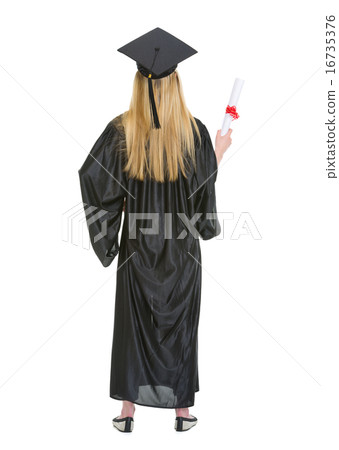 Full length portrait of woman in graduation gown showing diploma Full length portrait of woman in graduation gown showing diploma 16735376