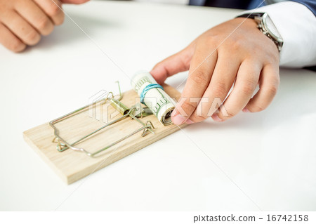 businessman taking money out of mousetrap 16742158