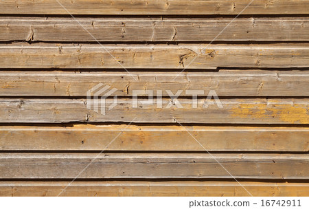 Old wooden wall with cracked yellow paint layer 16742911