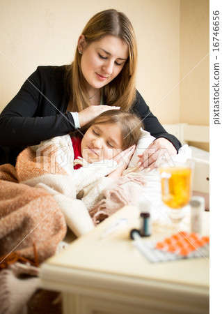 caring mother lying in bed with sick girl caring mother lying in bed with sick girl 16746656