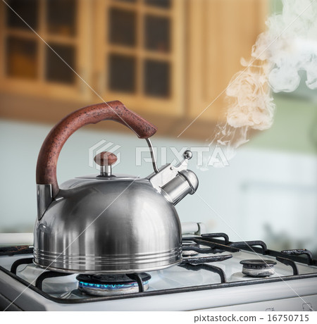 kettle boiling on a gas stove in the kitchen 16750715