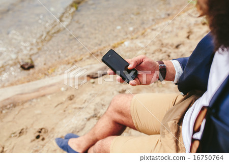 American Bearded Man using phone near the river 16750764