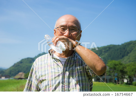 Senior drinking water while walking in the countryside Senior drinking water while walking in the countryside 16754667