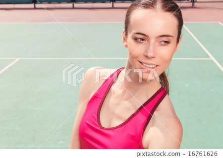 Pleasant girl staying on tennis court Pleasant girl staying on tennis court 16761626