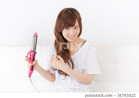 使用頭髮鐵的一個少婦 使用頭髮鐵的一個少婦 16763822