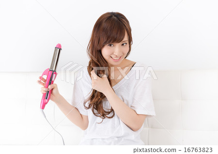 使用頭髮鐵的一個少婦 使用頭髮鐵的一個少婦 16763823