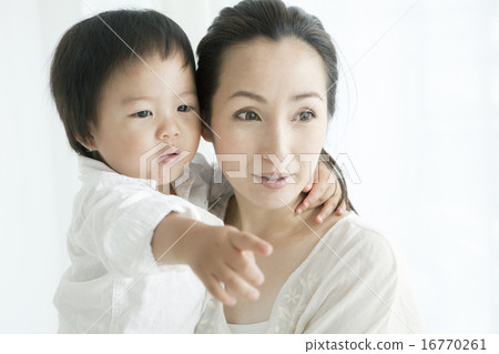 A woman in her twenties holding a child A woman in her twenties holding a child 16770261