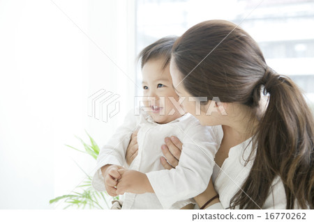 A woman in her twenties holding a child 16770262