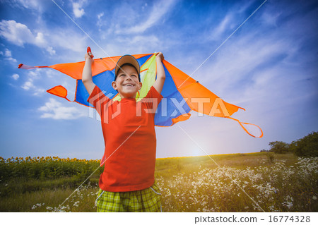 Kid flies a kite into the blue sky 16774328