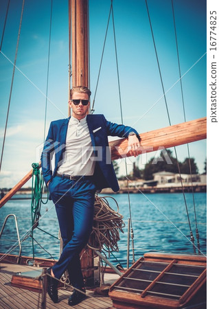 Stylish wealthy man on a luxury wooden regatta Stylish wealthy man on a luxury wooden regatta 16774825