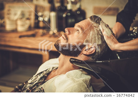 Hairstylist washing client's hair in barber shop Hairstylist washing client's hair in barber shop 16774842