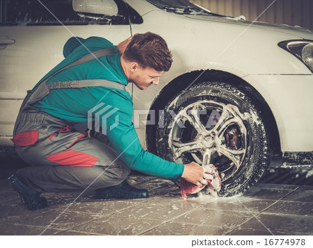 Man worker washing car's alloy rims on a car wash Man worker washing car's alloy rims on a car wash 16774978