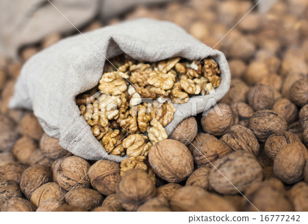 Walnuts kernels in the sack on the pile of walnuts Walnuts kernels in the sack on the pile of walnuts 16777242