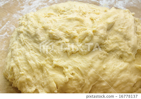 Closeup piece of kneaded yeasty raw dough Closeup piece of kneaded yeasty raw dough 16778137