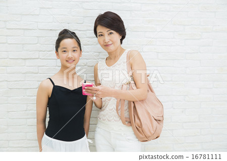 A mother who operates a smartphone and a teenage girl in ballet shape A mother who operates a smartphone and a teenage girl in ballet shape 16781111