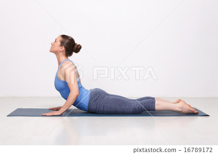 Sporty fit yogini woman practices yoga asana bhujangasana Sporty fit yogini woman practices yoga asana bhujangasana 16789172