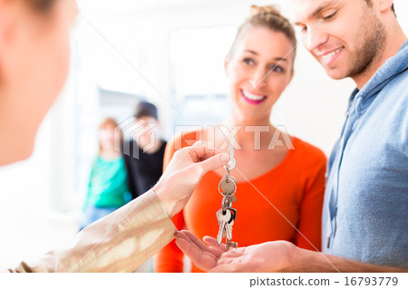 Accommodation broker giving home key to family Accommodation broker giving home key to family 16793779