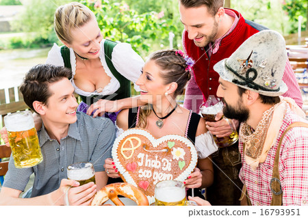 people with gingerbread heart in beer garden 16793951