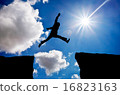 Man jumping across the gap from one rock 16823163