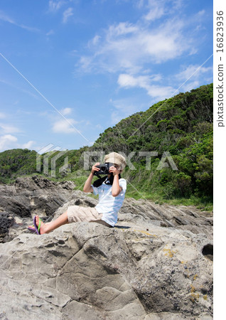 坐岩石地方和拍照片的孩子。小攝影師(三浦半島,長濱海岸) 坐岩石地方和拍照片的孩子。小攝影師(三浦半島,長濱海岸) 16823936