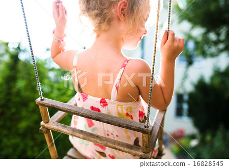 Happy girl having fun on a swing on summer day Happy girl having fun on a swing on summer day 16828545