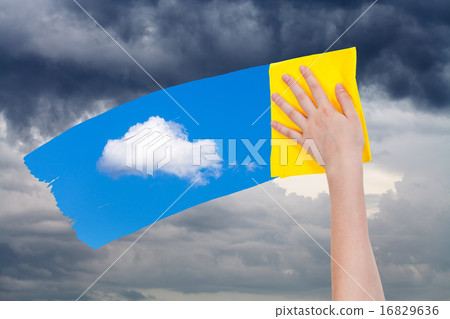 hand deletes rain clouds by yellow cloth hand deletes rain clouds by yellow cloth 16829636