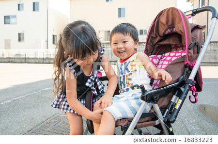 My older brother puts his brother on a stroller 16833223