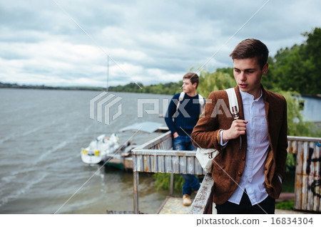 two young guys standing on a pier 16834304