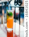 Orange cocktail with mint leaves outdoors 16841025