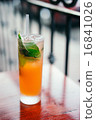 Orange cocktail with mint leaves outdoors 16841026