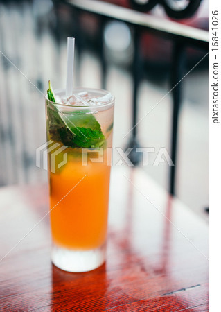 Orange cocktail with mint leaves outdoors Orange cocktail with mint leaves outdoors 16841026