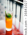 Orange cocktail with mint leaves outdoors 16841027