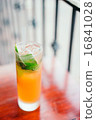 Orange cocktail with mint leaves outdoors 16841028