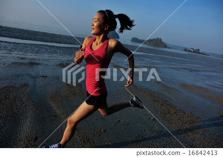 young woman running at sunrise beach 16842413