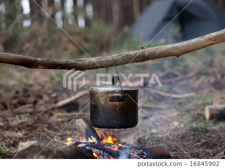 Cooking in sooty cauldron on campfire Cooking in sooty cauldron on campfire 16845902