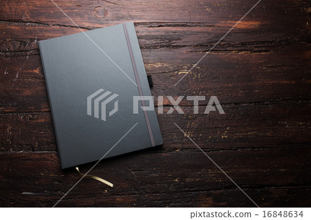 Notepad laying on a old dark wooden table Notepad laying on a old dark wooden table 16848634
