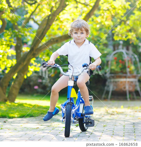Little preschool kid boy riding with bicycle in summer 16862658